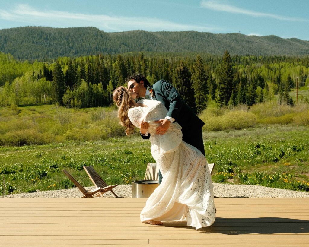 Erin and josh dancing together on the porch in the sun overlooking the mountains