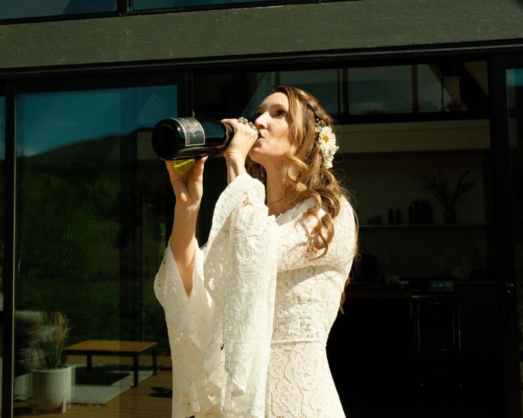 Erin drinking champagne on the porch with the airbnb in the background