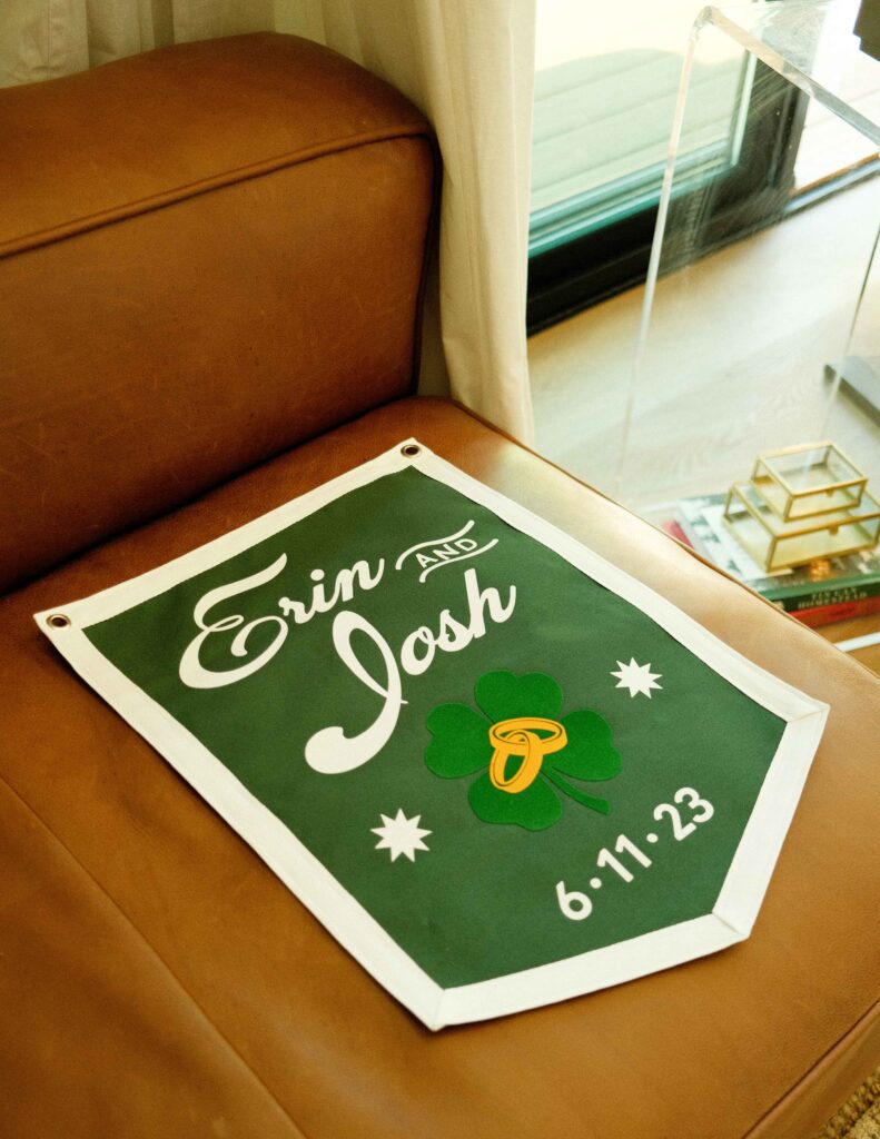 A green felt flag with their names, rings overlaying a shamrock and their wedding date