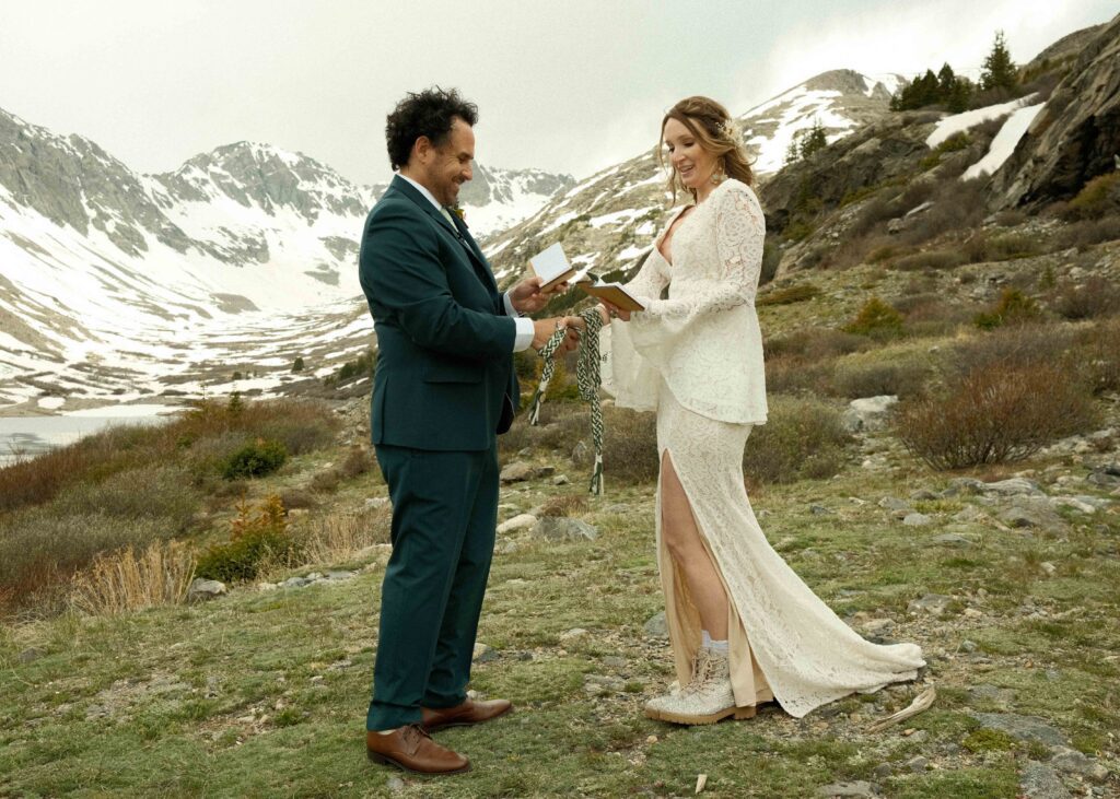 Erin and Josh officially eloping in the mountains of colorado in their wedding outfits during their hand fasting ceremony